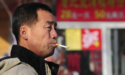 A man smokes his cigarette in Beiijng